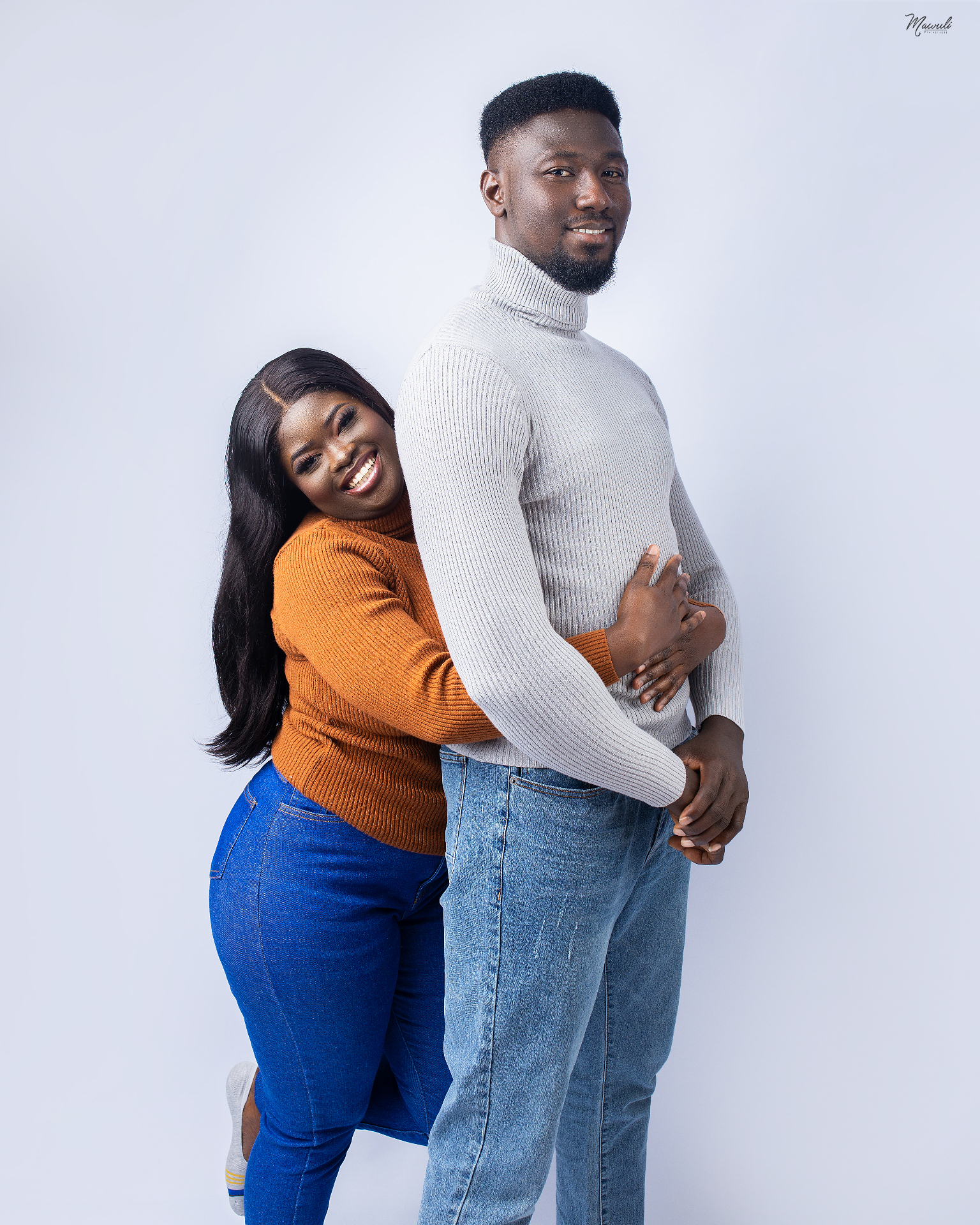 Kingsley and Thelma embracing in a portrait for their wedding website hero.